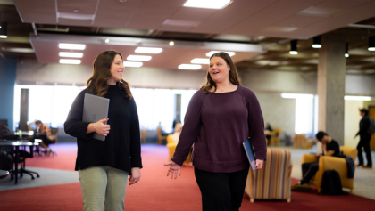 Two women standing together consulting